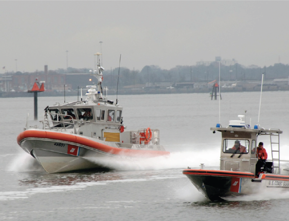 Two United States Coast Guard boats driving in water